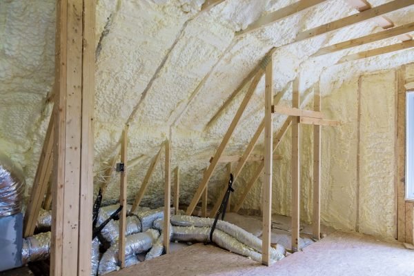 Building with wooden beams of a roof installing pipe heating system a house attic under construction